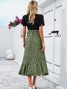 Vue arrière d'une robe bicolore élégante avec manches noires et jupe léopard verte