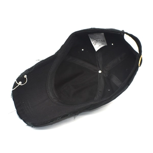Detail view of cotton baseball cap interior with wash label and metal ring accent