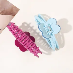 Macro view of large flower hair claws in pink and blue colors with glossy finish