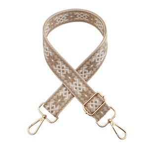 Close-up of bohemian jacquard strap with geometric patterns and gold metal swivel hooks