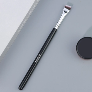 Détail du pinceau à sourcils biseauté professionnel avec manche en bois noir et virole