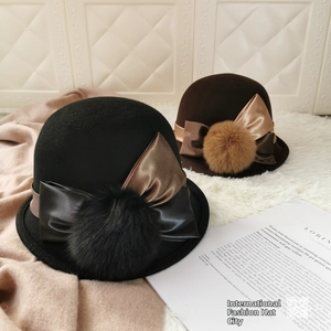Detail of wool felt bowler hats with decorative satin ribbon bows and fluffy pom poms
