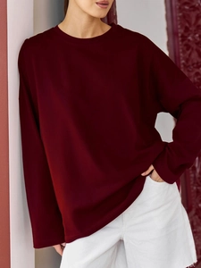 Nahaufnahme eines burgunderroten Langarm-Sweatshirts mit Rundhalsausschnitt und Baumwolltextur