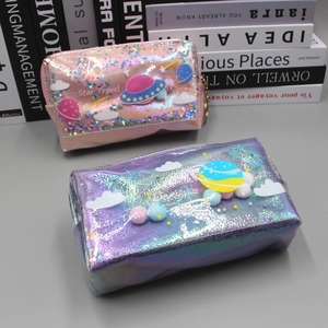 Close-up of glittery cosmic makeup bags with liquid star sequins and planet patches