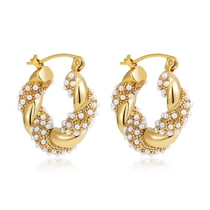 Detail of 18K gold twisted hoop earrings featuring intricate pavé pearls and pavé diamonds