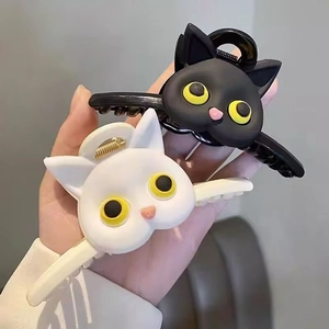 Detail of matte black and white cat-shaped triangular hair claw clips with pink noses
