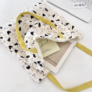 Detail of quilted canvas tote with cute kitten prints and vibrant yellow handles