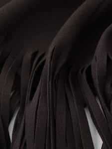 Macro shot showcasing the intricate tassel fringe detail on a dark brown wool coat fabric