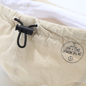 Adjustable beige vintage cotton dad hat with elastic drawstring and toggle closure details