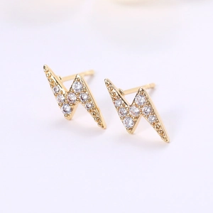 Macro shot of gold lightning bolt stud earrings with sparkling cubic zirconia inlay