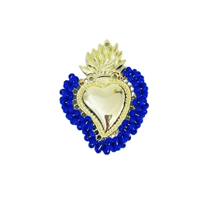 Detailed view of handmade golden sacred heart pendant with blue beaded outline
