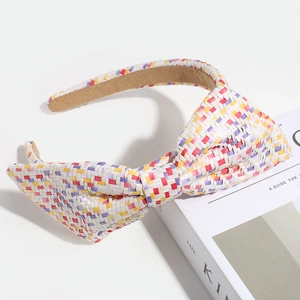 Detail of colorful woven headband with bow on a magazine, showing texture and vibrant colors