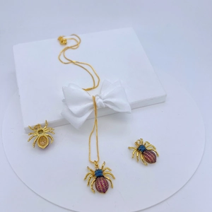 Nahaufnahme von goldenem Spinnen-Schmuckset mit bunten Zirkonia-Kristallen auf weißer Box