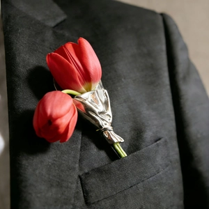 Detailansicht einer silbernen Tulpenstrauß-Brosche an einem schwarzen Blazer-Sakko