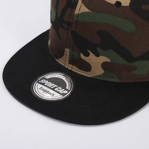 Macro shot of camouflage snapback hat with flat black brim and sport cap stickers