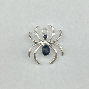 Detailed view of a silver spider pendant with black rhinestones and top connector ring