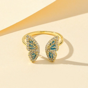Detail of a gold-plated butterfly ring with blue enamel and sparkling crystal accents