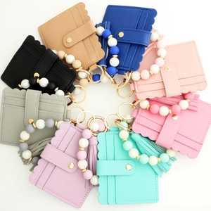 Flat lay of silicone bead bracelets with matching PU leather wallets in eight various colors