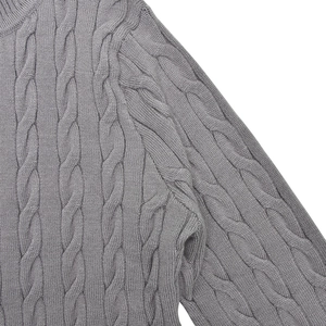 Détail de la maille torsadée grise sur l'épaule et la manche du pull ajusté
