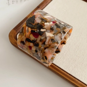 Detail of wide open-cuff acetate resin bangle with vintage tortoiseshell color pattern