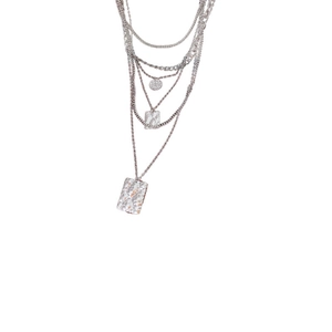 Layered silver square pendant necklace with unique hammered texture on white background