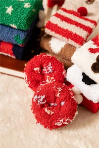 Close-up of fuzzy Christmas coral fleece socks in assorted festive patterns and colors