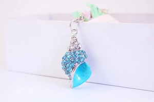 Detailed close-up of a blue rhinestone conch keychain with silver-plated metal base