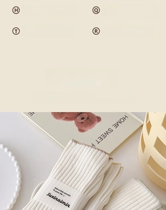Detail of off-white ribbed cotton socks with minimalist brand labels in warm lighting