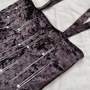 Close-up of velvet tote bag featuring decorative white pearls and radial pattern embroidery