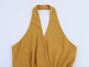 Dettaglio del top all'americana giallo zenzero con scollo a V incrociato e tessuto