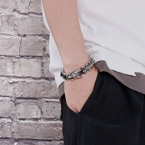 Dettaglio del bracciale vintage in acciaio argentato con incisioni ossee di drago punk