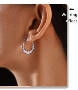Detail showing wearing effect of silver hammered texture C-shaped hoop earrings