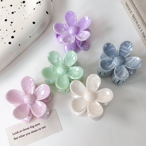 Détail de cinq pinces à cheveux en forme de fleurs marbrées dans un décor raffiné