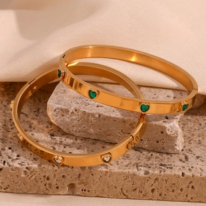 Detail of 18K gold-plated bracelets with green and white heart-shaped zircon stones