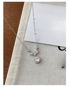 Detail of silver S925 necklace with circular zircon pendant and small crystals on chain