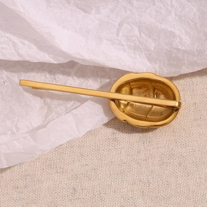 Detailed close-up of 18K gold-plated hair clip with irregular hammered lava texture