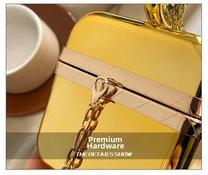 Detailed view of glossy gold evening bag with quilted metallic trim and fine chain strap