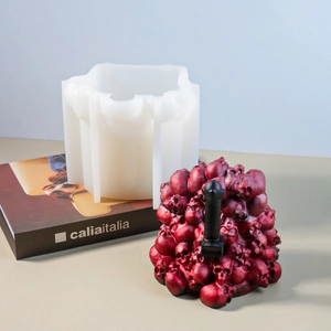 Macro view of translucent silicone mold and burgundy skull resin bookend with black handle