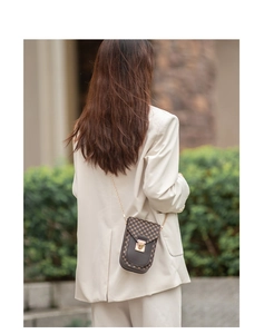 Vintage geometric pattern mini crossbody bag shown on model with gold chain strap