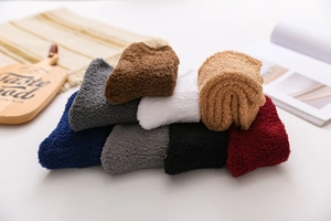 Close-up of soft coral fleece winter socks in multiple colors neatly folded on a desk