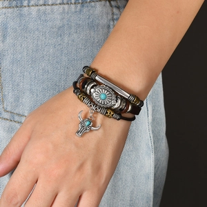 Close-up of a vintage leather layered bracelet with turquoise beads and a bull head charm