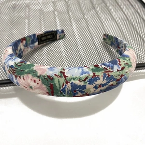 Padded bohemian headband with floral print pattern on a metallic mesh surface