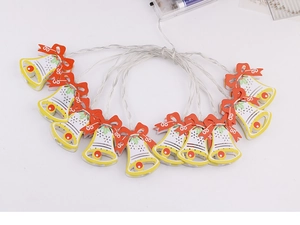 Macro detail of Christmas bell LED string lights with red bows and battery pack