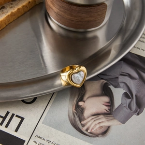 Minimalist 18K gold stainless steel heart ring with pearl inlay on a vintage tray