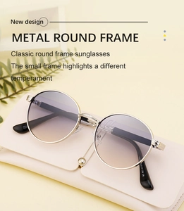 Detail of round metal frame sunglasses with gradient lenses and cream leather case