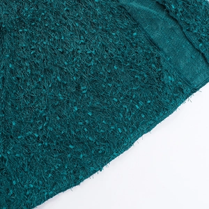 Detailed macro view of dark green plush knit fabric texture on backless halter dress