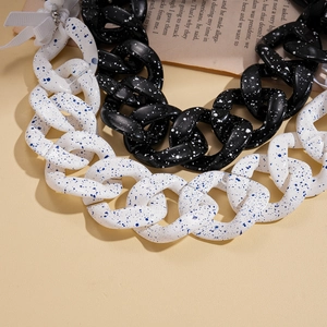 Chunky acrylic sweater necklace with splash ink pattern on a minimalist background