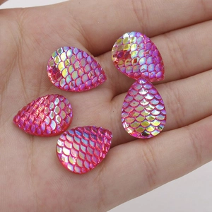 Close-up of pink fish scale resin droplets with AB colorful coating for DIY jewelry
