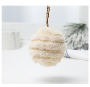 Close-up of creamy white felt wool ball ornament with spiral texture and jute rope string