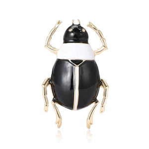 Fashionable black and white enamel beetle brooch with gold-plated legs on white background